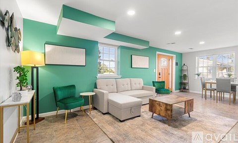 A living room with a green chair and a white couch.