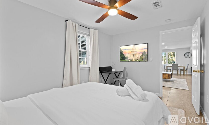 A bedroom with a large bed and a ceiling fan.