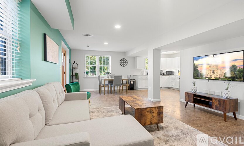 A living room with a large couch and a television on the wall.