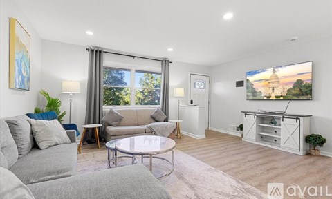 A living room with a grey sofa, a coffee table, and a painting on the wall.