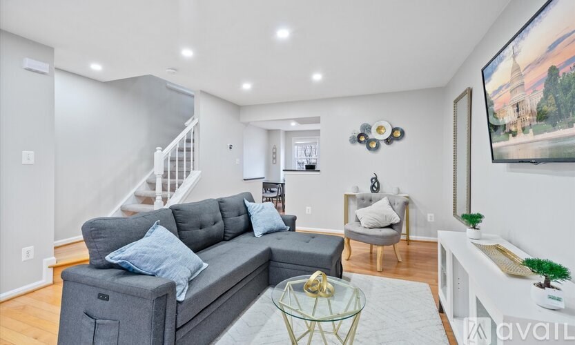 A living room with a grey sofa and a glass coffee table.