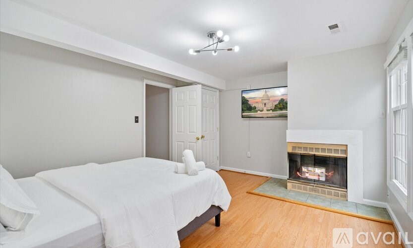 A bedroom with a fireplace and a painting on the wall.