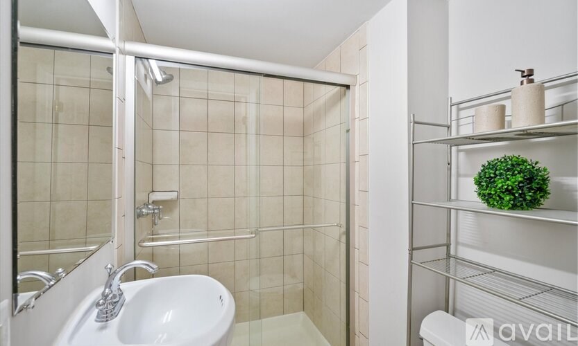 A white sink with a chrome faucet in a tiled bathroom.