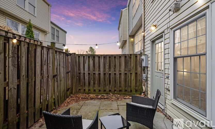 A backyard with a wooden fence and patio furniture.