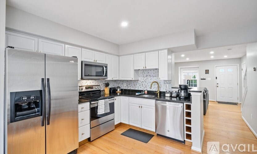 A modern kitchen with stainless steel appliances and white cabinets.