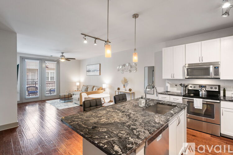 A kitchen with a black granite countertop and stainless steel appliances.