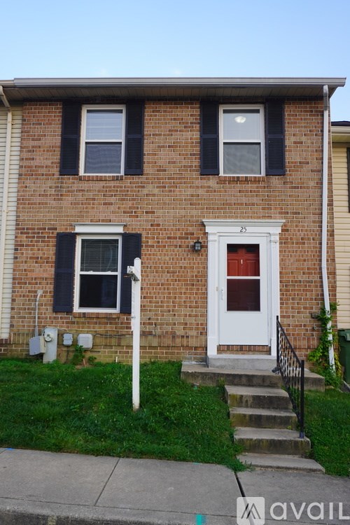 A brick house with a white door and black shutters.
