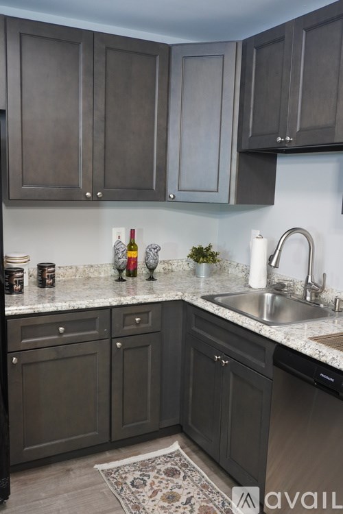 A kitchen with dark cabinets and a marble countertop.