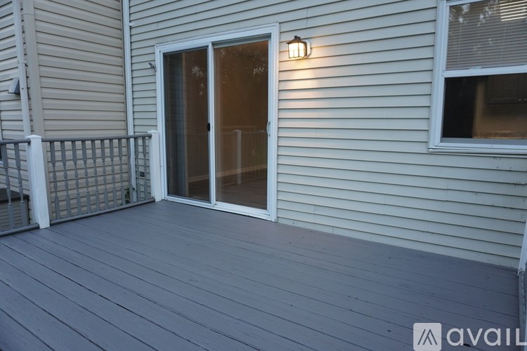 A deck with a sliding glass door and a small porch light.