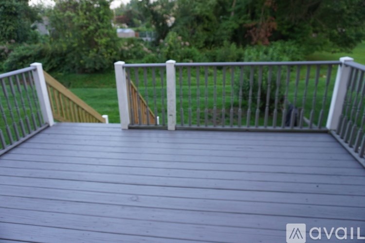A wooden deck with a metal railing and a gate.