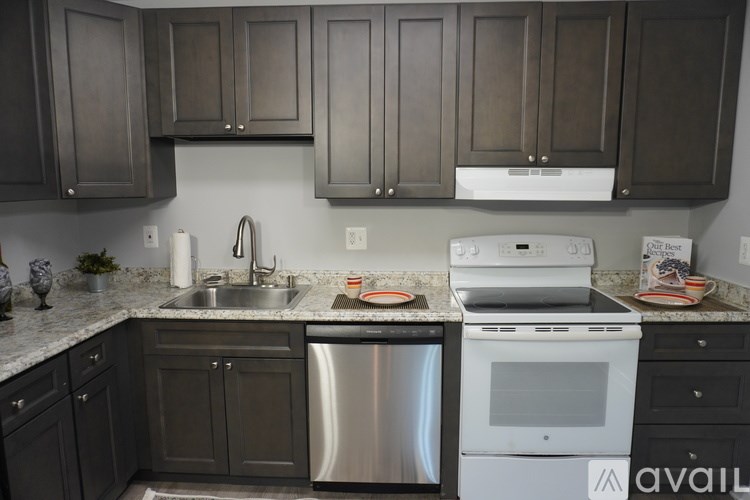 A kitchen with a stainless steel dishwasher and white oven.