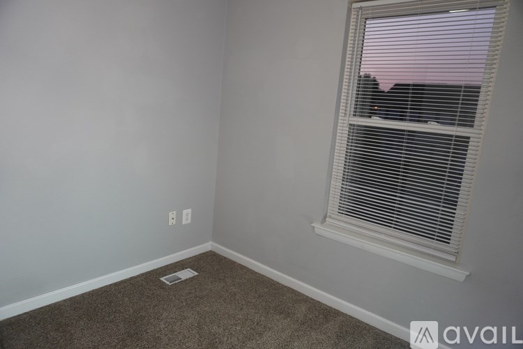 A room with a window and a carpet on the floor.