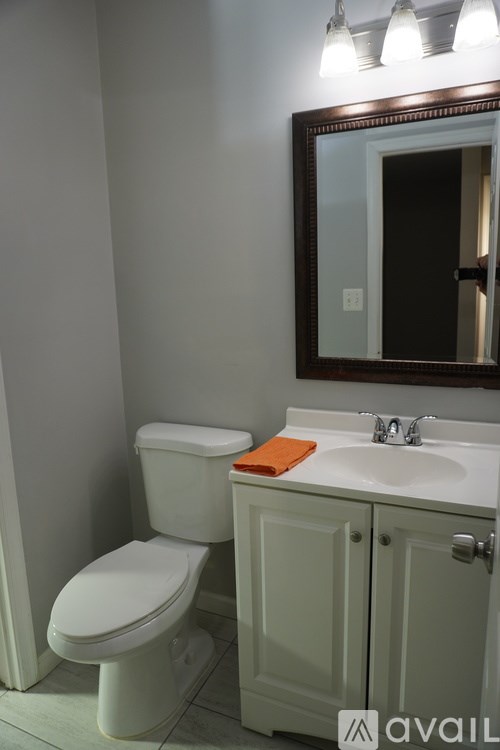 A white toilet sits next to a sink in a bathroom.