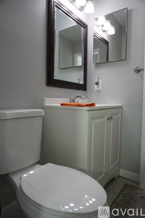 A white toilet sits next to a sink in a bathroom.