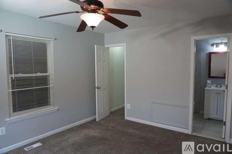A room with a ceiling fan and a window with blinds.