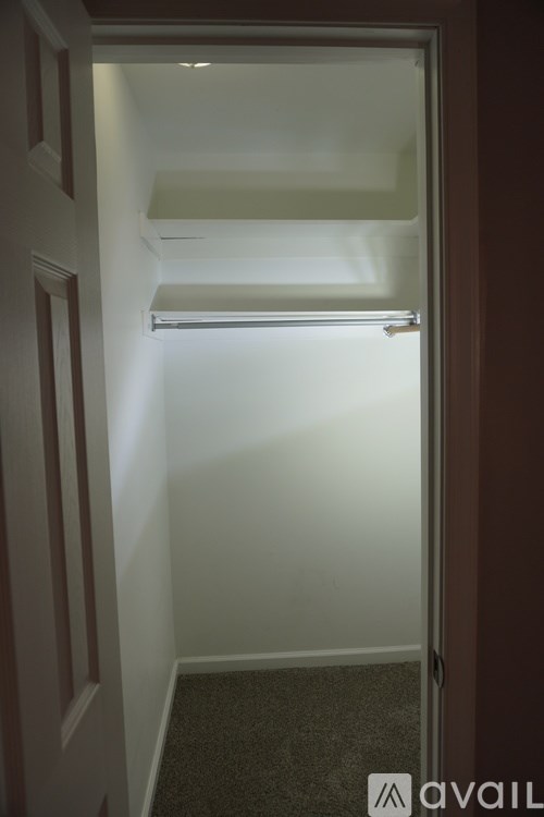 A small, dark room with a doorway leading to another room.