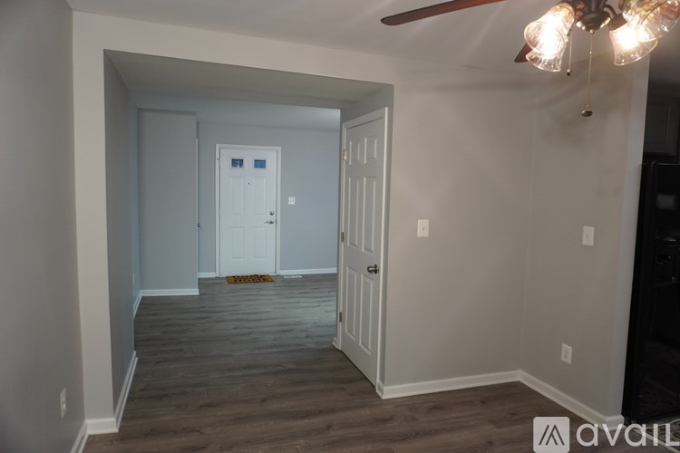 A room with a white door and a ceiling fan.