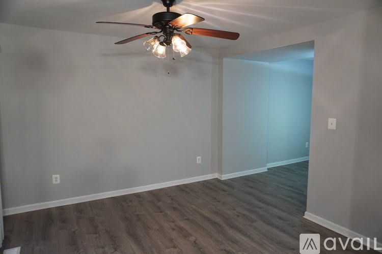 A room with a ceiling fan and light fixture.