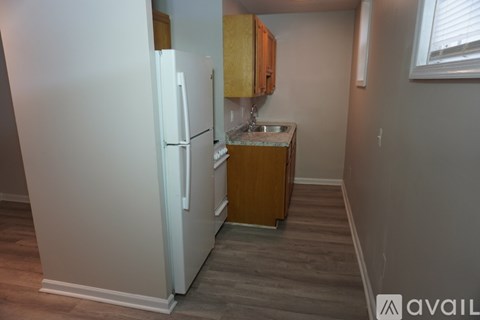 A kitchen with a white refrigerator and wooden cabinets.