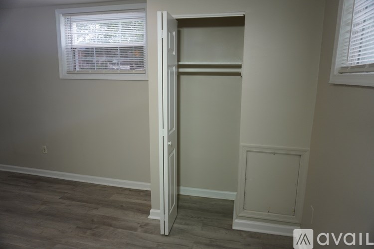 A room with a door open and a window with blinds.