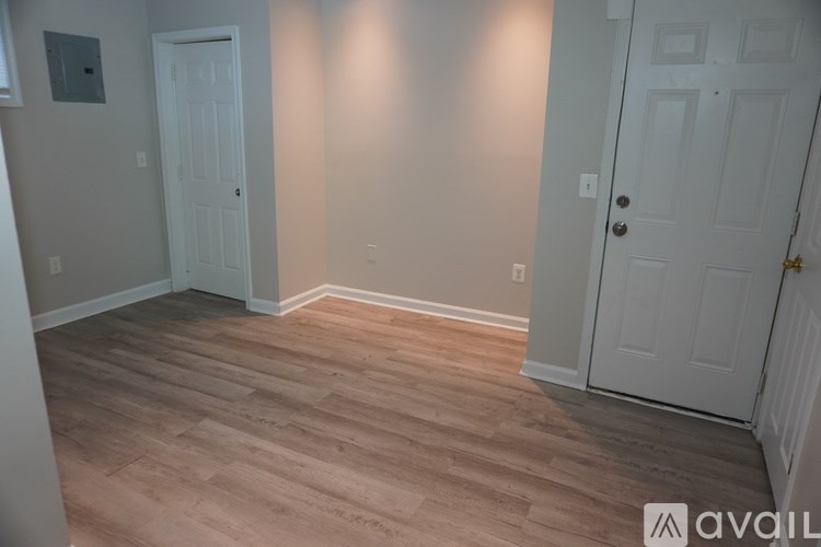 A room with wood flooring and two white doors.