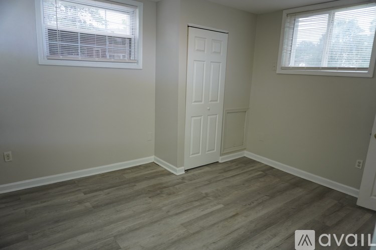 A room with a white door and a window with blinds.