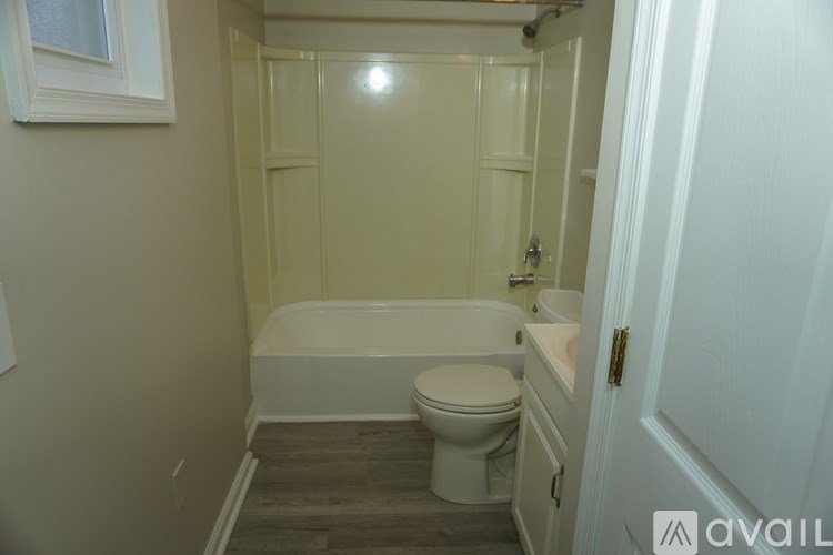 A bathroom with a toilet, sink and bathtub.