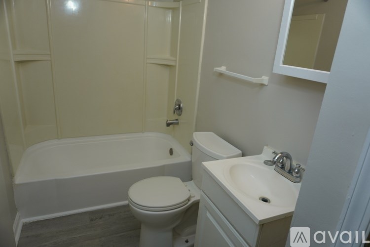 A white toilet sits next to a white sink in a bathroom.
