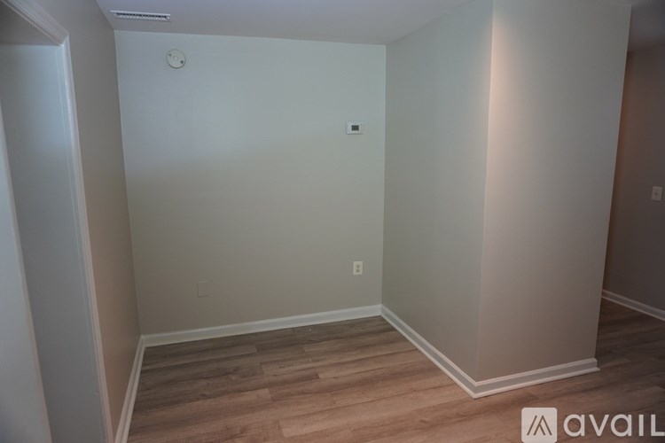 A room with wooden flooring and white walls.