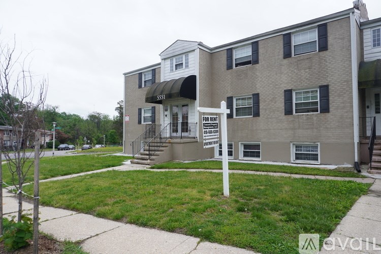 A building with a sign that says "For Rent" in front of it.