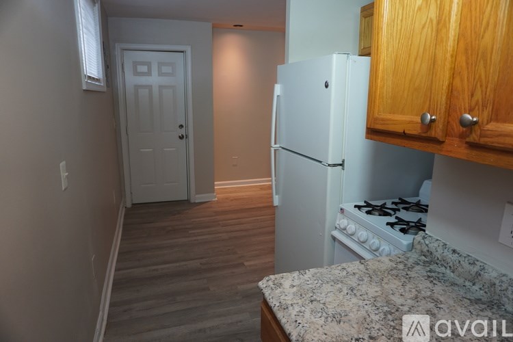 A kitchen with a white refrigerator and a granite counter top.