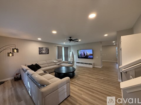 A spacious living room with a large couch and a television.