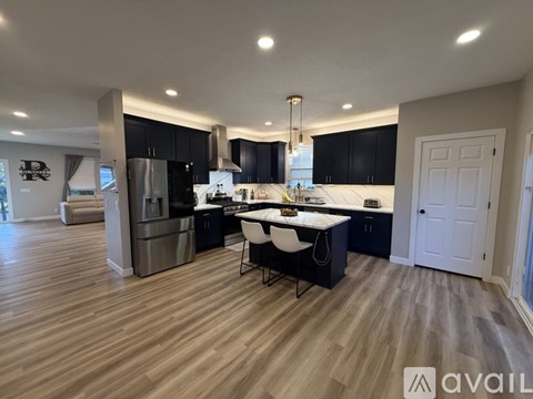 A modern kitchen with a large island and stainless steel appliances.