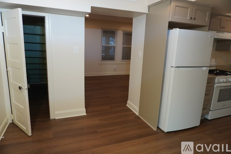A kitchen with a white refrigerator and wooden floors.