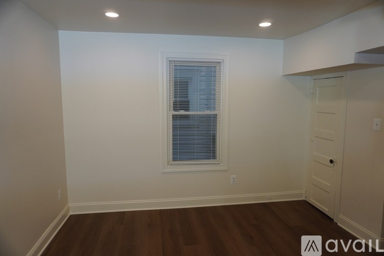 A room with a window and wooden floors is available for rent.
