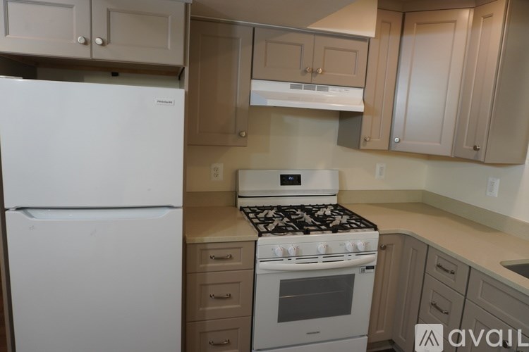 A kitchen with a white fridge and a white stove top oven.