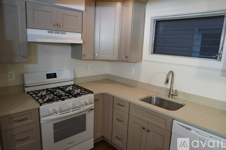 A kitchen with a white stove top oven and a white dishwasher.