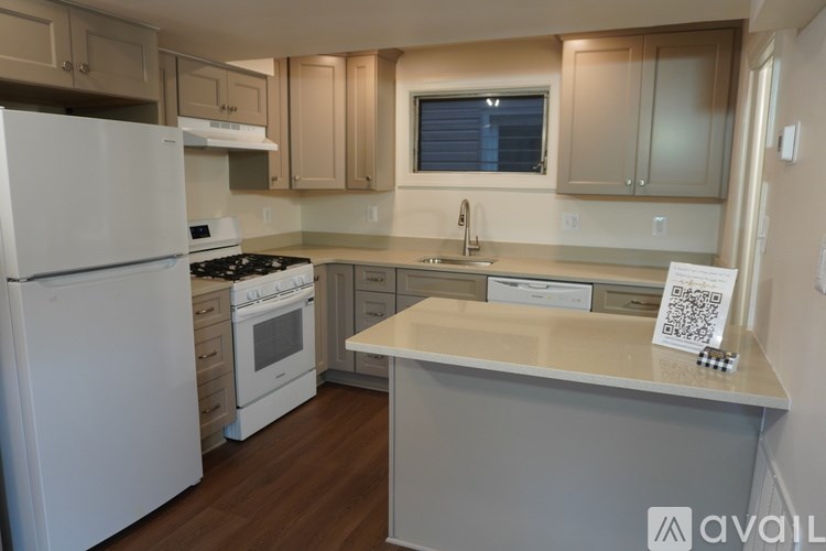 A kitchen with white appliances and wooden cabinets.