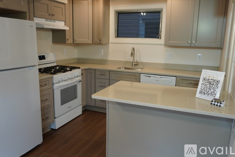 A kitchen with white appliances and wooden cabinets.