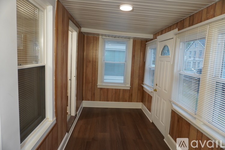 A room with wooden walls and a window with blinds.