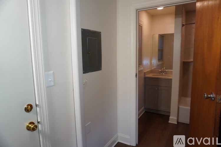 A bathroom with a white door and a mirror.
