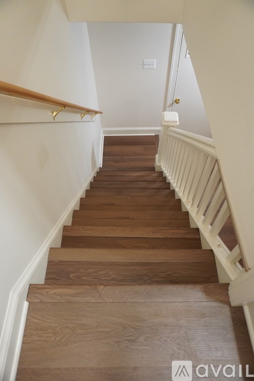 A wooden staircase with white railings.