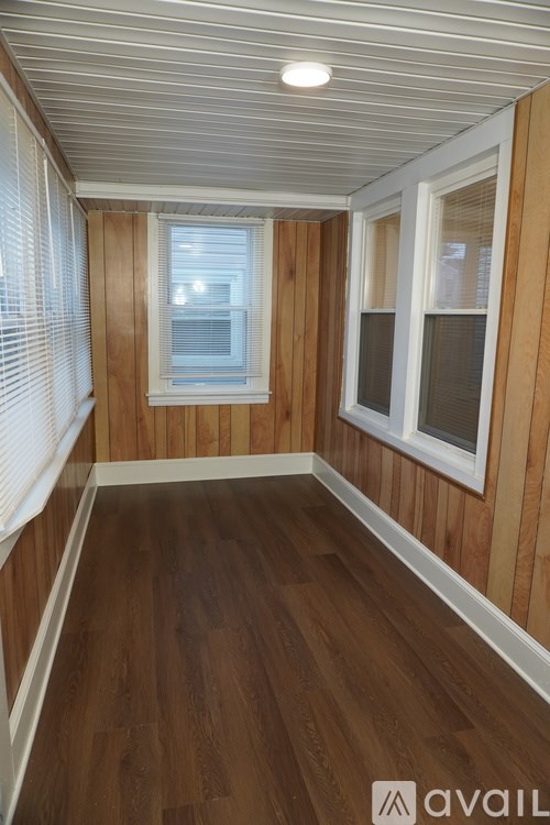 A room with wooden walls and a window with blinds.