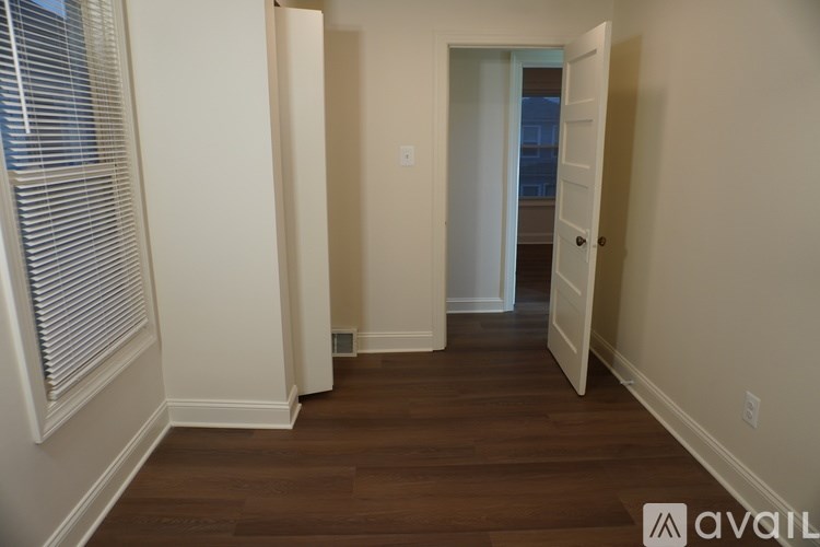 A hallway with wood floors and white walls.