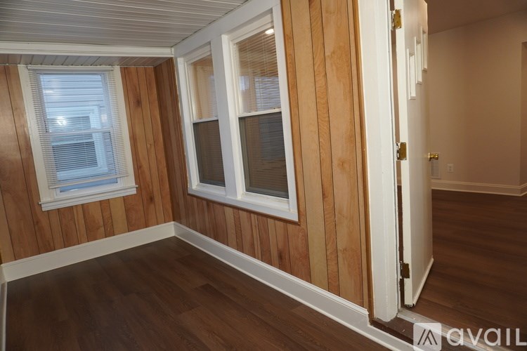 A room with wooden walls and a window with blinds.