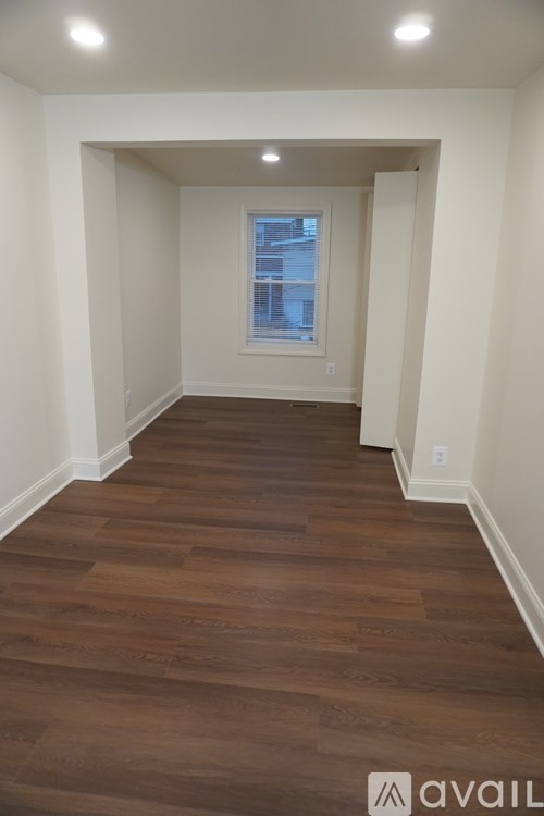 A room with wooden flooring and a window.