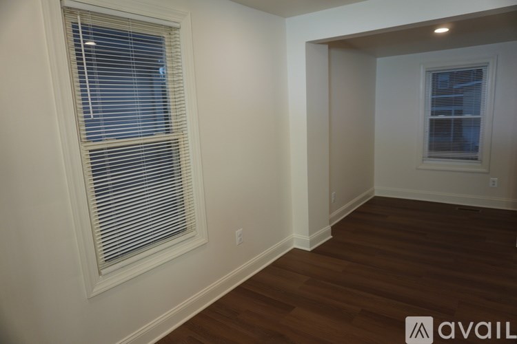 A room with a window and wooden flooring.