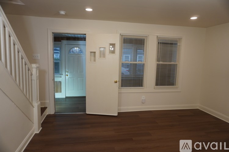 A room with a white door and a window with blinds.