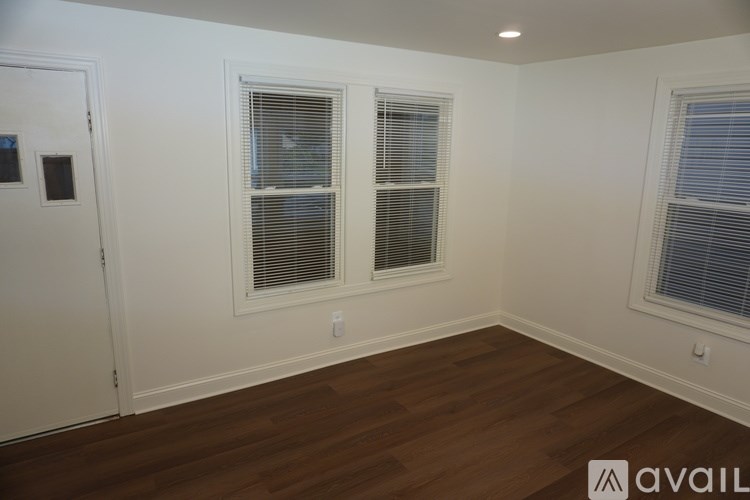 A room with two windows and wooden flooring.
