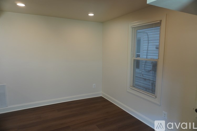 A room with a window and wooden floors.